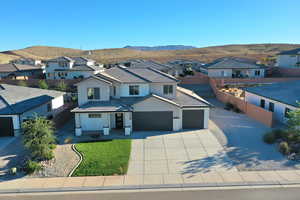 View of front of home with a residential view, stucco siding, concrete driveway, and a mountain view