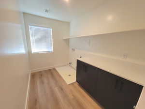 Laundry room with light wood-type flooring, washer hookup, and hookup for an electric dryer