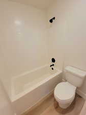 Full bath with shower / tub combination and wood finished floors