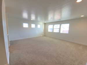 Spare room featuring light carpet, a textured ceiling, and recessed lighting