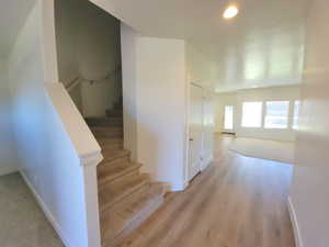Staircase with recessed lighting and wood finished floors