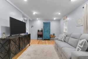Living area featuring original hardwood flooring and recessed lighting