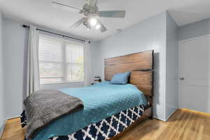 Bedroom featuring original hardwood flooring, ceiling fan, and a mountain view