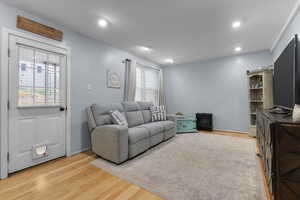 Living area featuring original hardwood flooring and recessed lighting and back door