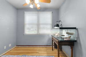 Bedroom 1 with original hardwood flooring and a ceiling fan
