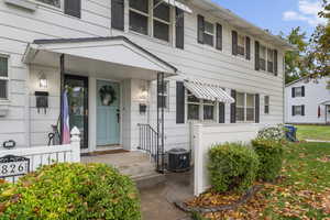 Front porch with small fenced area and large grassy front yard.