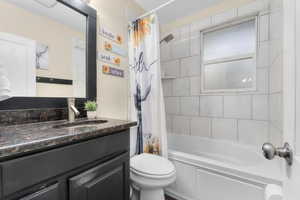 Full bath with tile shower/tub combo, granite countertop vanity, and slate tile flooring