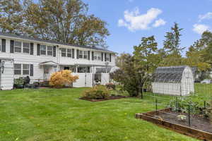 Back of house with 2 garden boxes and the neighbor's shed