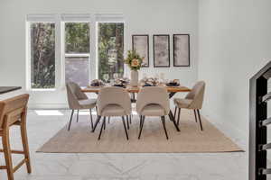 Dining area with light marble finish flooring and baseboards