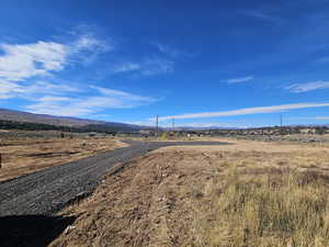 View of gravel driveway with a mountain view and a rural view