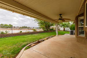 Fenced backyard featuring ceiling fan and a patio
