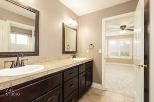 Bathroom featuring double vanity, a shower with curtain, light carpet, light tile patterned flooring, and a ceiling fan