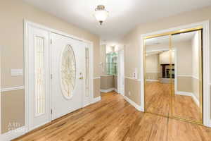 Entrance foyer featuring light wood finished floors and a fireplace