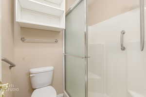 Bathroom featuring a stall shower and toilet