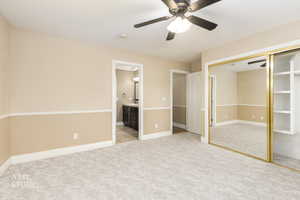 Unfurnished bedroom with light carpet, ceiling fan, a closet, and connected bathroom