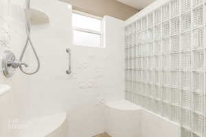 Full bathroom with tiled shower and tile walls