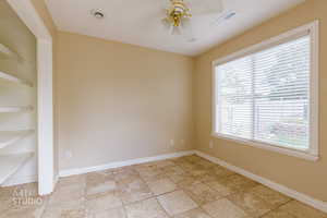 Empty room with ceiling fan and built in features