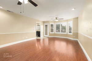 Unfurnished room with wood finished floors, ceiling fan, recessed lighting, and a fireplace
