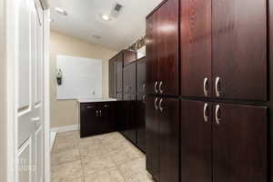 Bathroom featuring a closet, light tile patterned flooring, vanity, and recessed lighting