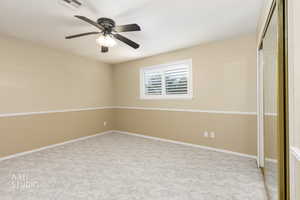 Unfurnished bedroom featuring a closet, light colored carpet, and ceiling fan
