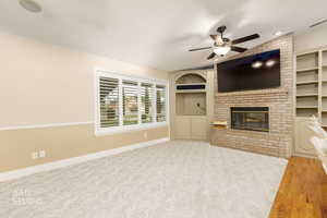 Unfurnished living room with a fireplace, vaulted ceiling, and a ceiling fan