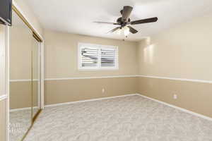 Unfurnished bedroom featuring a closet, carpet flooring, ceiling fan, and a textured ceiling