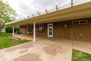 Rear view of property with a patio area, stucco siding, a ceiling fan, and a lawn