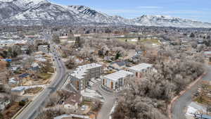 Aerial view of property and surrounding area featuring a mountain backdrop and nearby suburban area