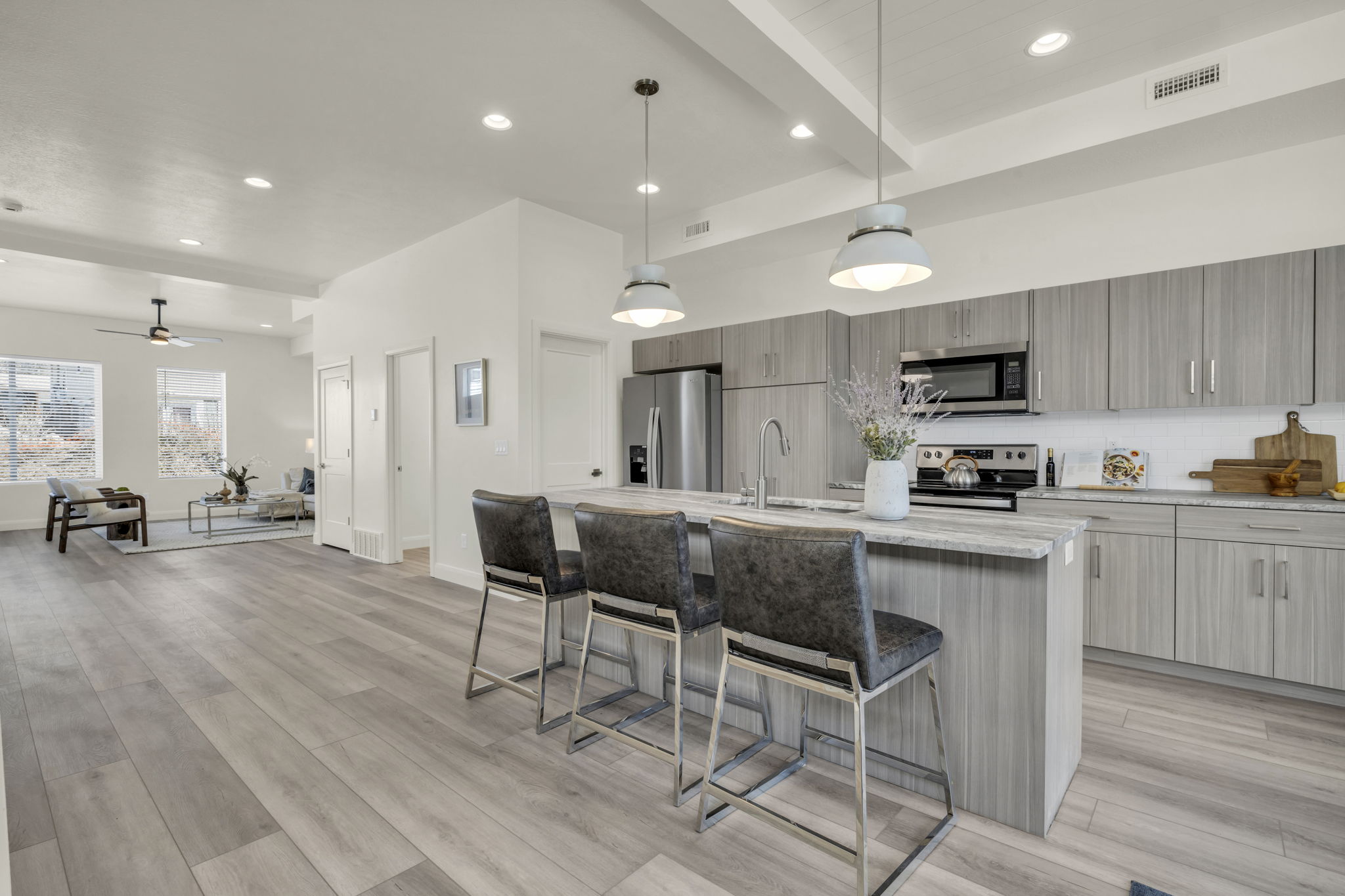 Kitchen featuring hanging light fixtures, recessed lighting, a kitchen breakfast bar, appliances with stainless steel finishes, and beam ceiling