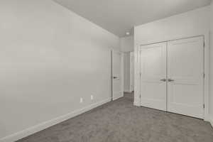 Unfurnished bedroom featuring carpet flooring and a closet