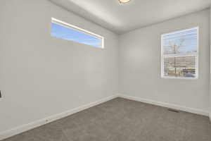 Empty room featuring baseboards and carpet flooring