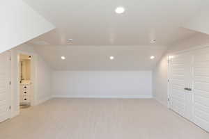 Bonus room with light colored carpet and recessed lighting