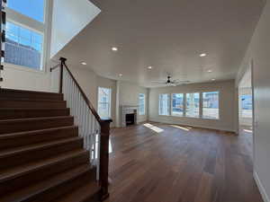 Unfurnished living room with a fireplace, dark wood-style floors, a textured ceiling, recessed lighting, and ceiling fan