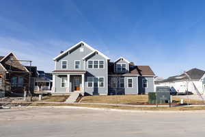 View of front of property with covered porch and a front yard