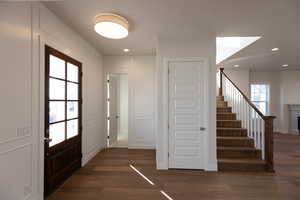 Foyer with a decorative wall, dark wood-style flooring, recessed lighting, and a fireplace
