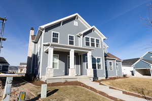 View of front facade featuring a porch, a chimney, and a front yard