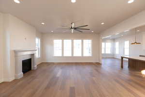 Unfurnished living room featuring a fireplace, a ceiling fan, light wood-type flooring, and recessed lighting