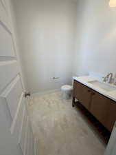 Half bathroom with vanity and toilet