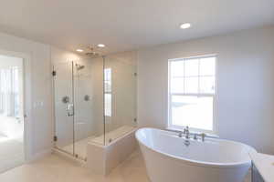 Full bathroom with a soaking tub, a shower stall, and recessed lighting