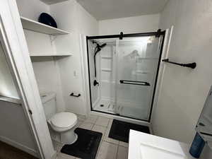 Updated three-quarter bath showcasing new fixtures, shelving, and a contemporary walk-in shower.