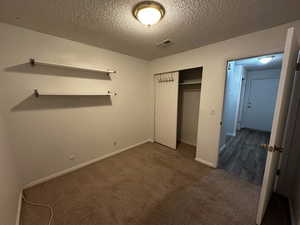 Alternate view of the secondary bedroom highlighting space, shelving, and natural light.