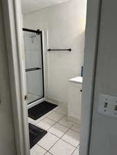 Fully remodeled three-quarter bath with glass shower doors, modern finishes, and tile flooring.
