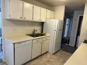 Kitchen with light countertops and white appliances