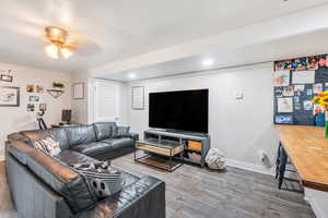 Living area featuring wood finished floors and a ceiling fan