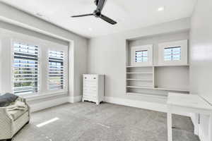 Home office with carpet floors and a ceiling fan
