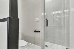 Bathroom with a shower stall and toilet