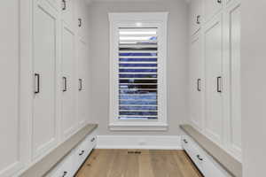 Mudroom featuring light wood finished floors and wine cooler