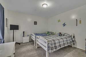 Bedroom with light colored carpet and a textured ceiling