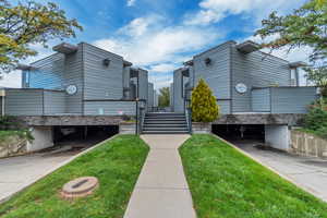 View of community featuring stairway and a lawn