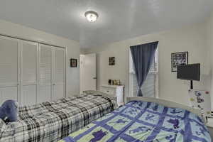 Bedroom with a textured ceiling and a closet